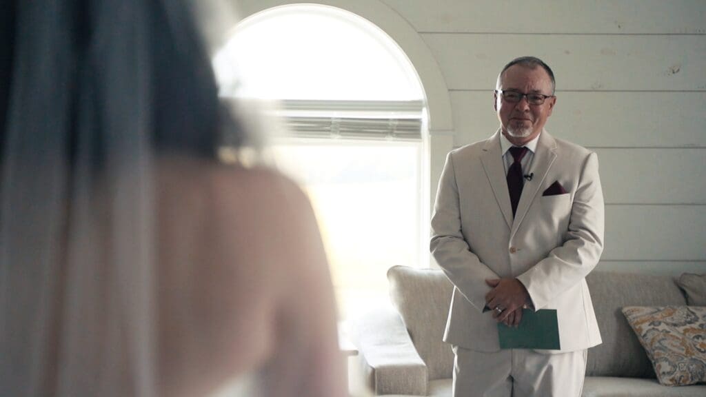 Emotional first look moment between the bride and her father inside a Missouri wedding venue.