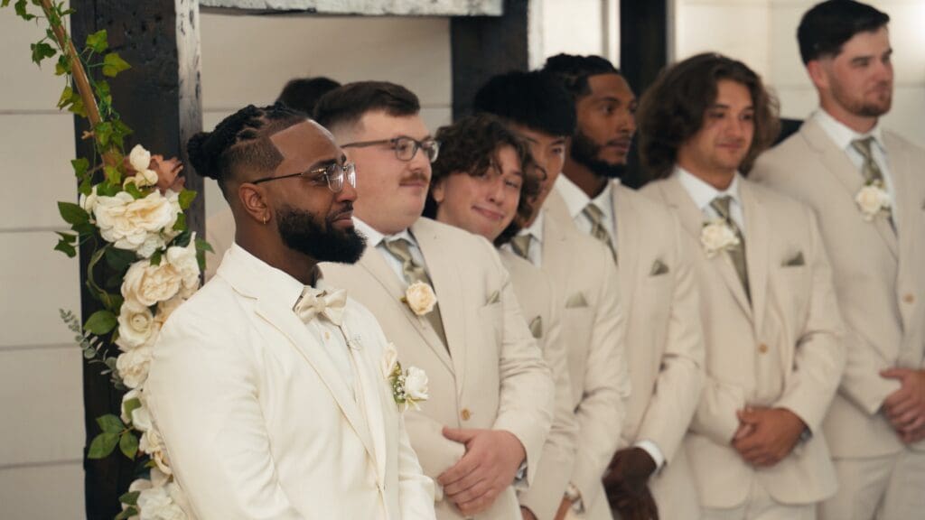 Groom standing with groomsmen during an outdoor barn wedding ceremony in Missouri.