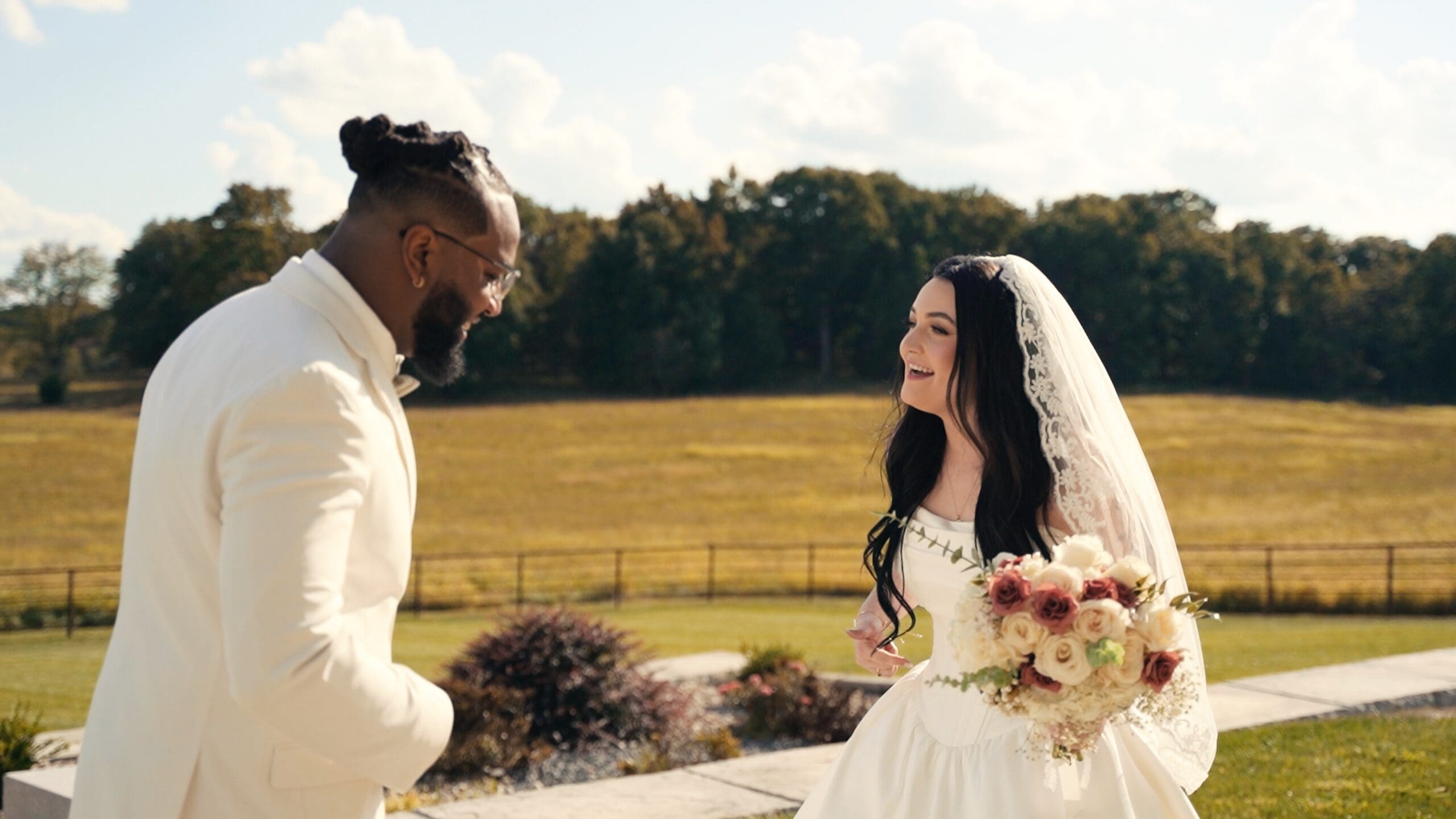 Bride and groom sharing a joyful first look outside at their Missouri barn wedding