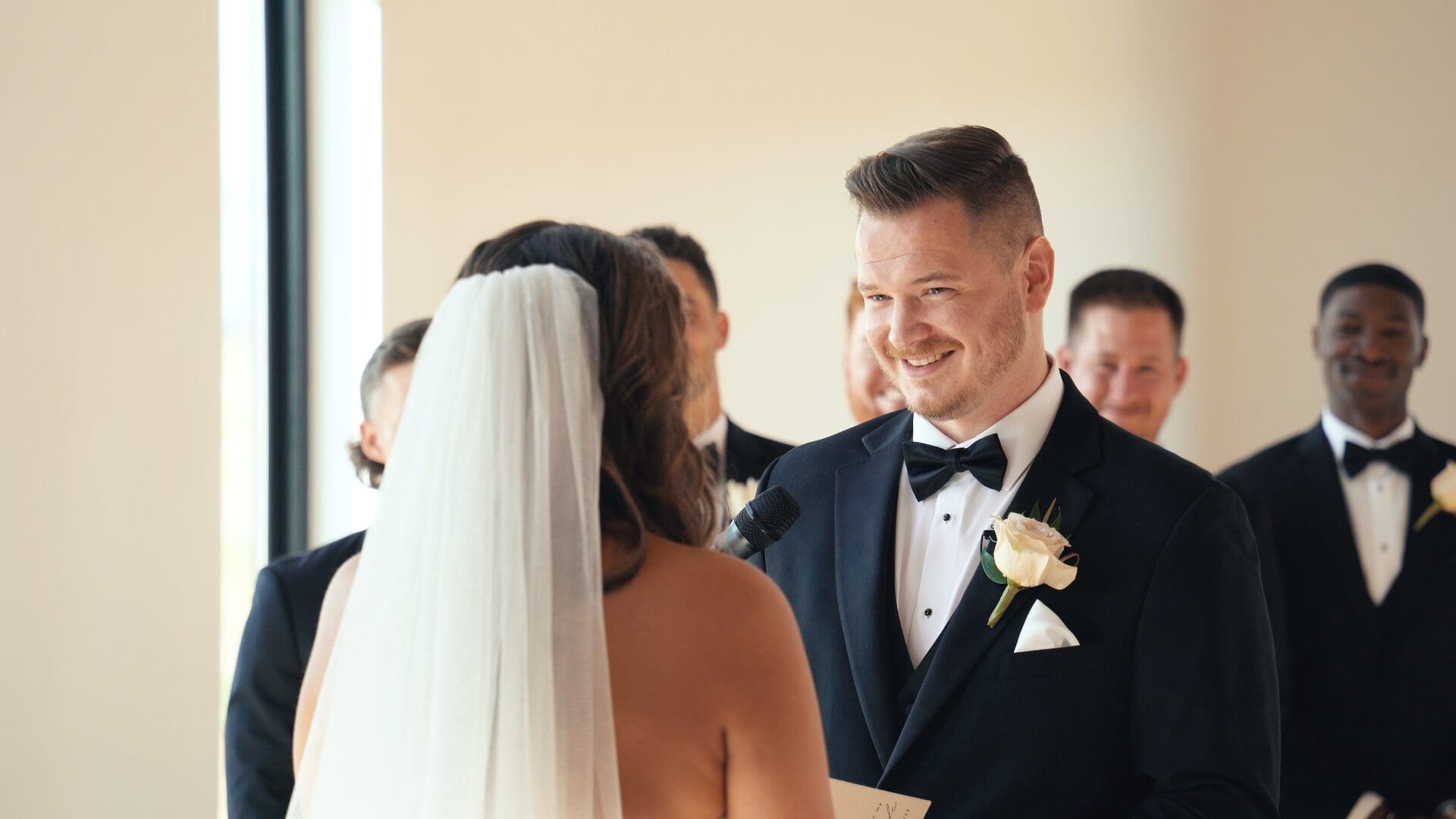 Groom smiling as he speaks during the wedding ceremony vows