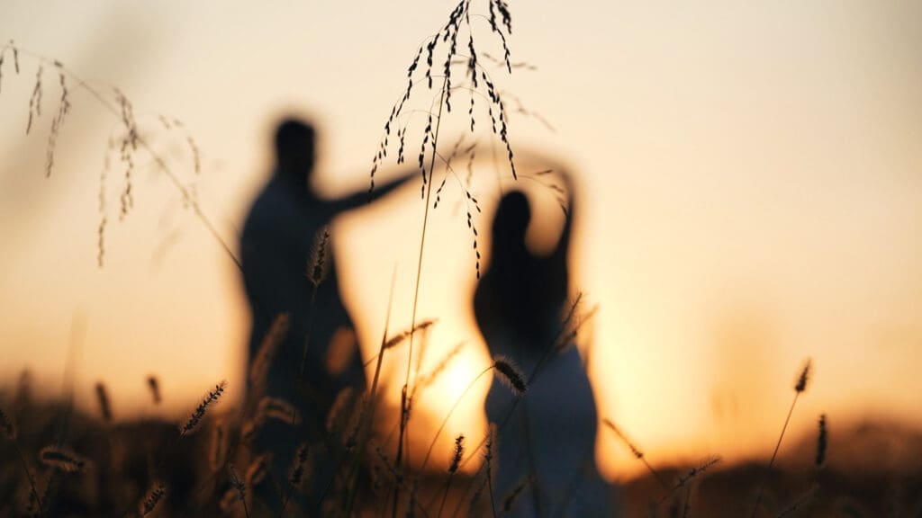 Bride and groom dancing in a field during golden hour at Red Oak Valley