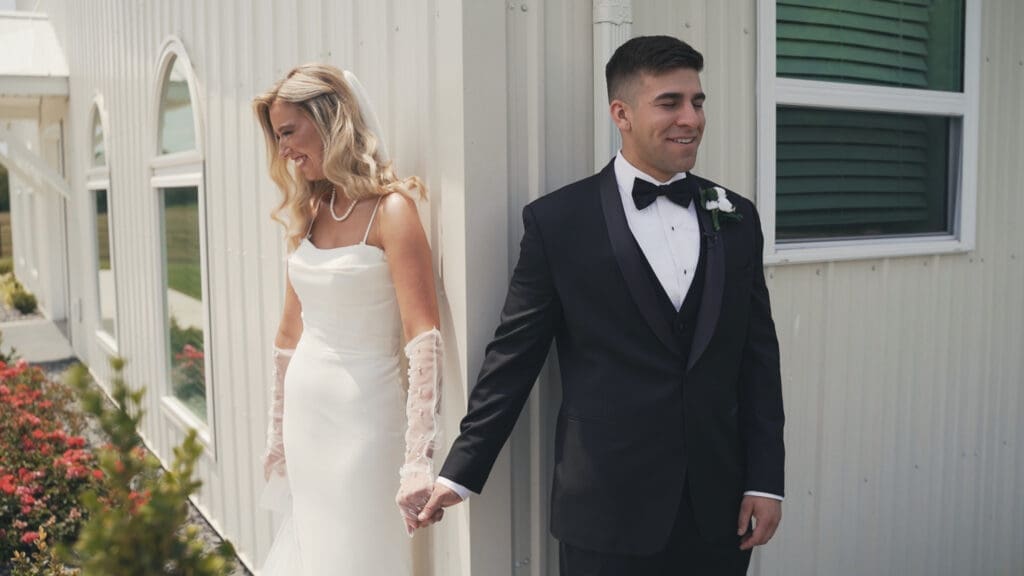 Bride and groom holding hands during a first touch outside the White Barn at Red Oak Valley