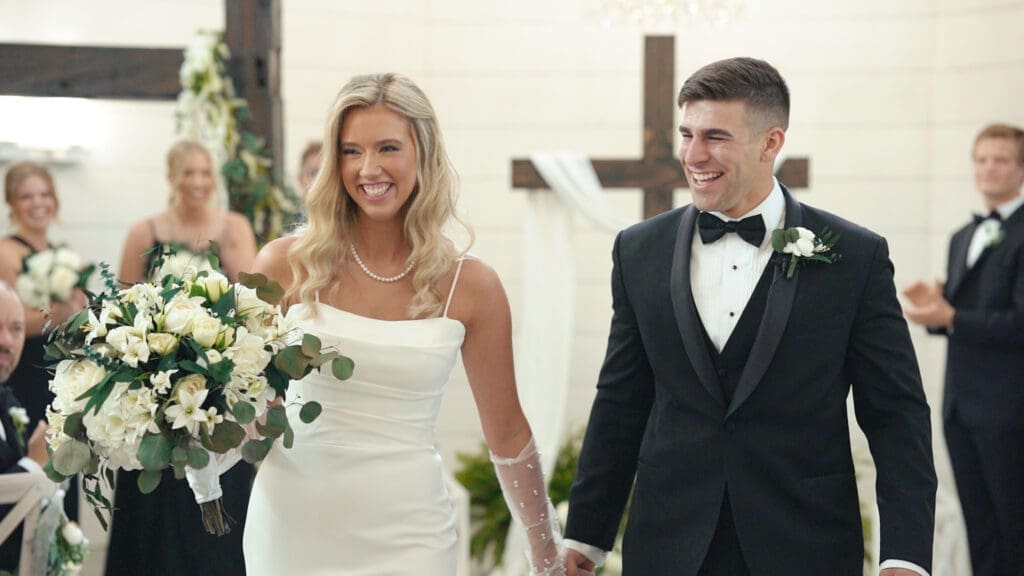 Bride and groom smiling after their wedding ceremony inside the White Barn at Red Oak Valley