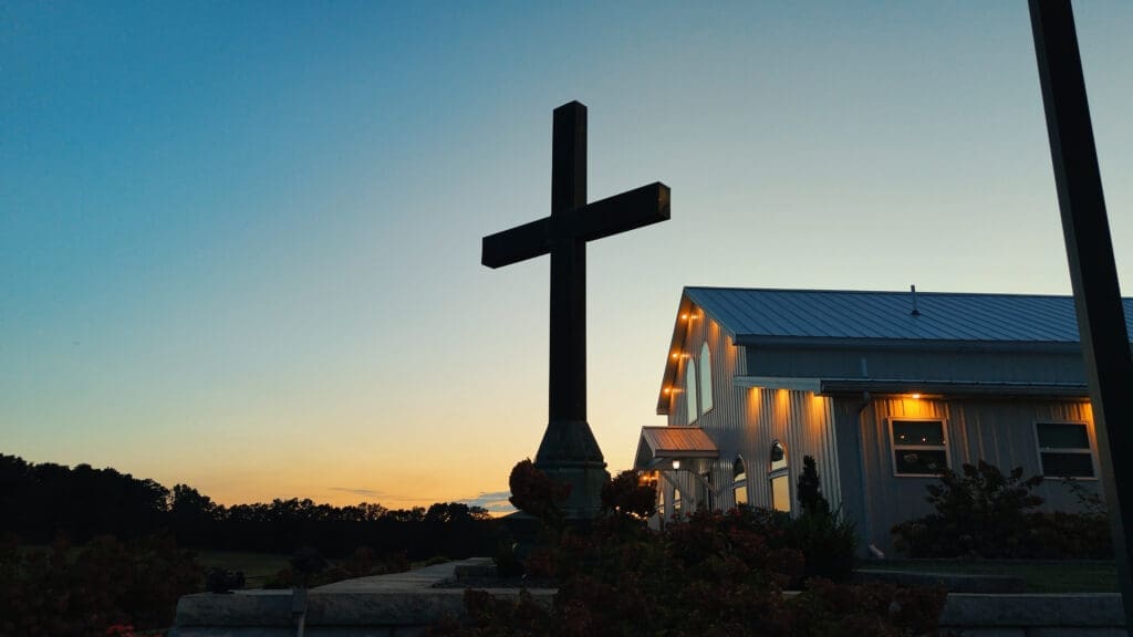 Red Oak Valley White Barn wedding venue at sunset with a large wooden cross